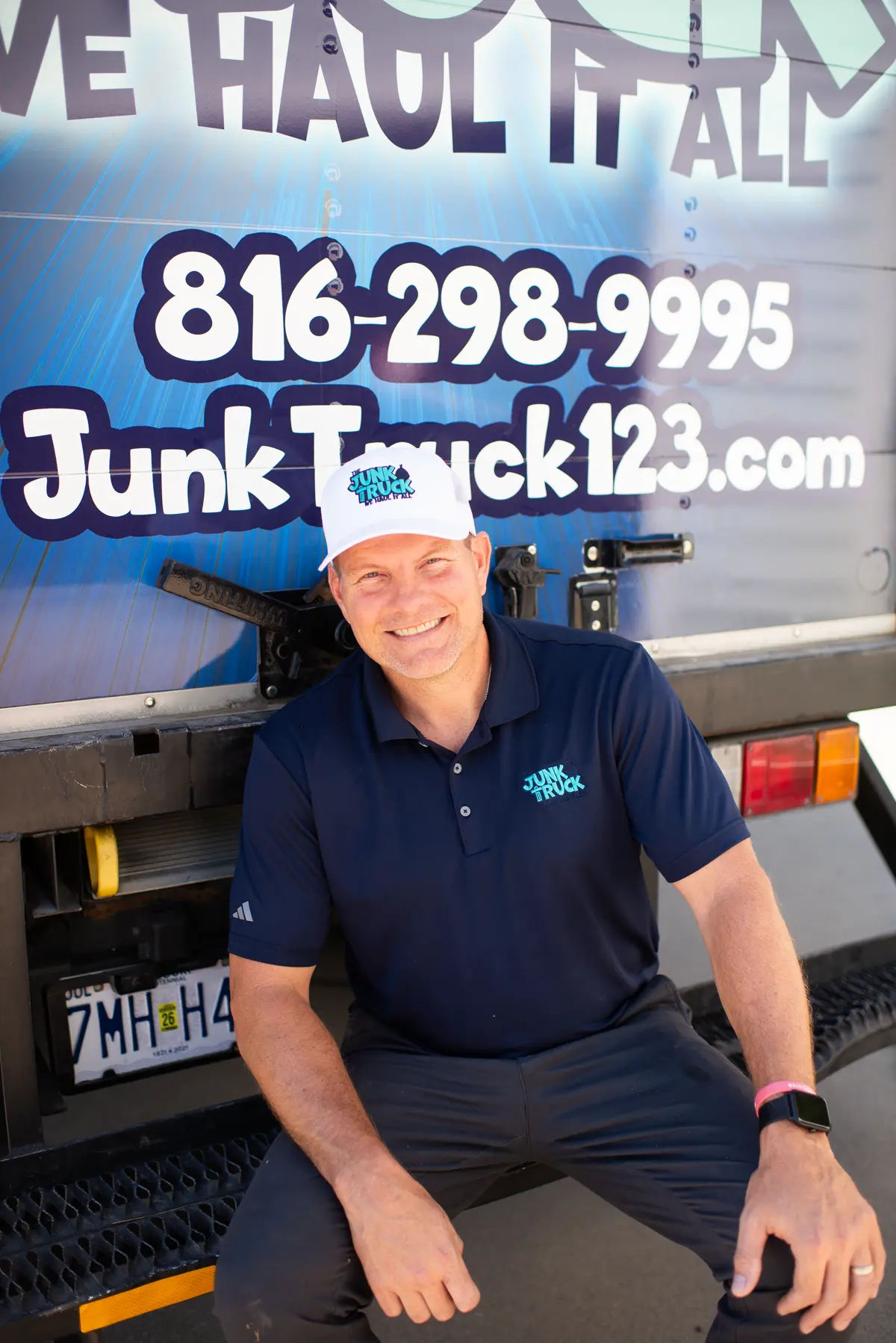 Collin Grote, owner of The Junk Truck, standing in front of his branded truck in Kansas City